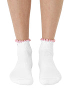 White socks with pink lining, equipped with stay-put grips to prevent slipping, shown worn on a white background.