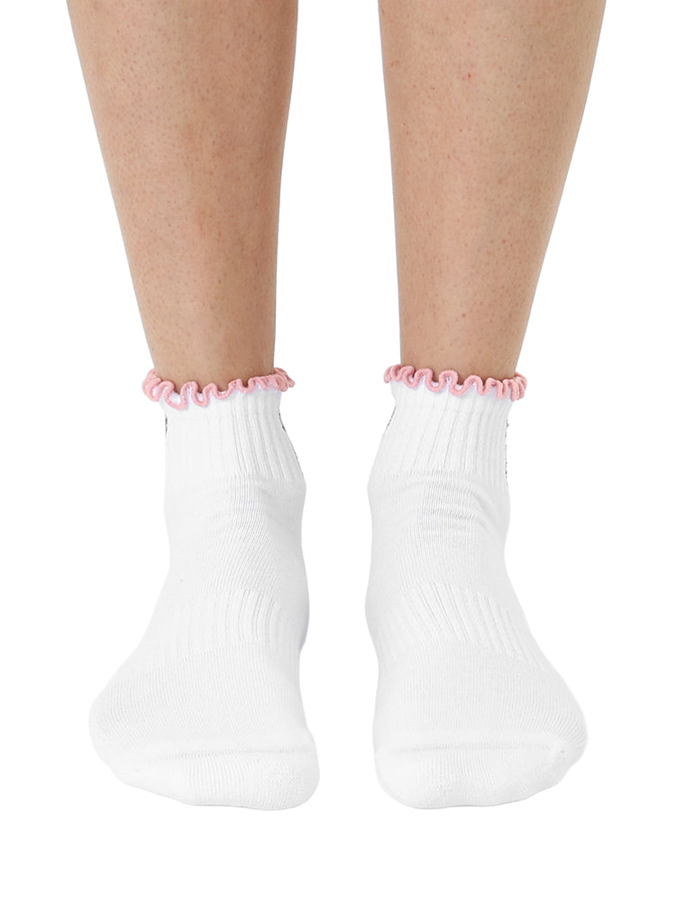 White socks with pink lining, equipped with stay-put grips to prevent slipping, shown worn on a white background.