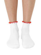 White socks with super sticky, stay-put grips to help prevent slipping, featuring a small chili pepper print worn on a white background.