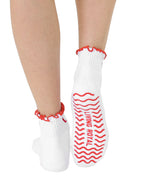 White socks with super sticky, stay-put grips to help prevent slipping, worn on a white background.