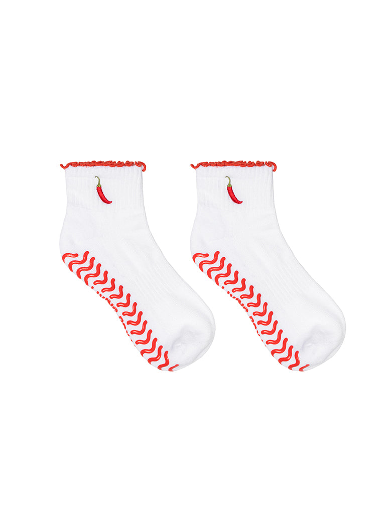 White socks with super sticky, stay-put grips to help prevent slipping on a white background.