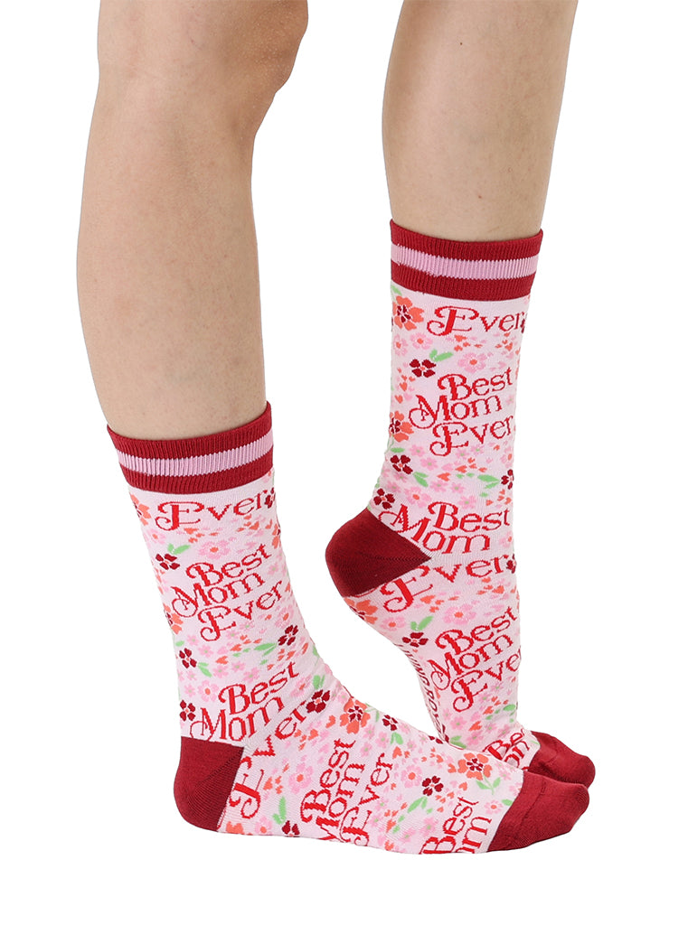 Pink and red women’s bamboo crew socks featuring a “Best Mom Ever” print with a floral pattern, shown worn on a person against a white background.