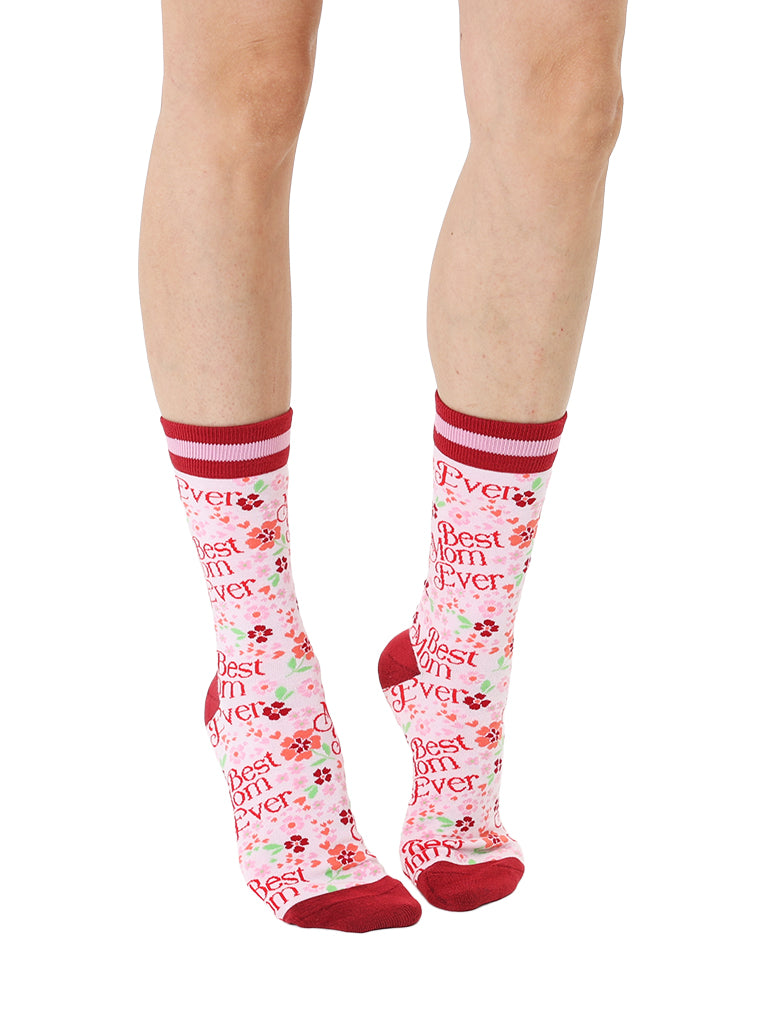 Pink and red women’s bamboo crew socks featuring a “Best Mom Ever” print with a floral pattern, shown worn on a person against a white background.