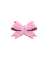 Pink compact mirror with a bow design, perfect for quick touch-ups on the go, displayed on a white background.