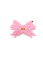 Pink compact mirror with a bow design, perfect for quick touch-ups on the go, displayed on a white background.