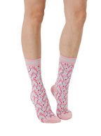 Pink and grey women’s bamboo crew socks featuring a delicate bow pattern print, shown worn on a person against a white background.