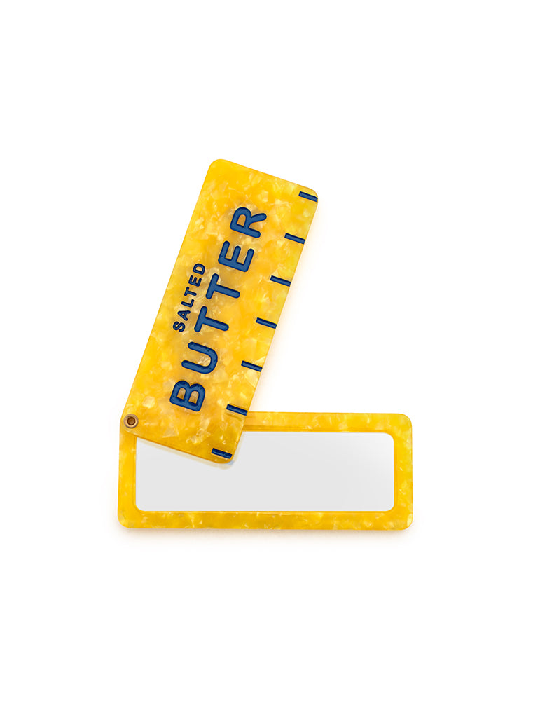 Yellow compact mirror featuring a salted butter print, perfect for on-the-go touch-ups, displayed on a white background.