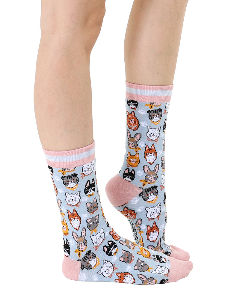 Women’s bamboo crew socks featuring a variety of cat face–themed patterns, shown worn on a person against a white background.