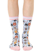 Women’s bamboo crew socks featuring a variety of cat face–themed patterns, shown worn on a person against a white background.