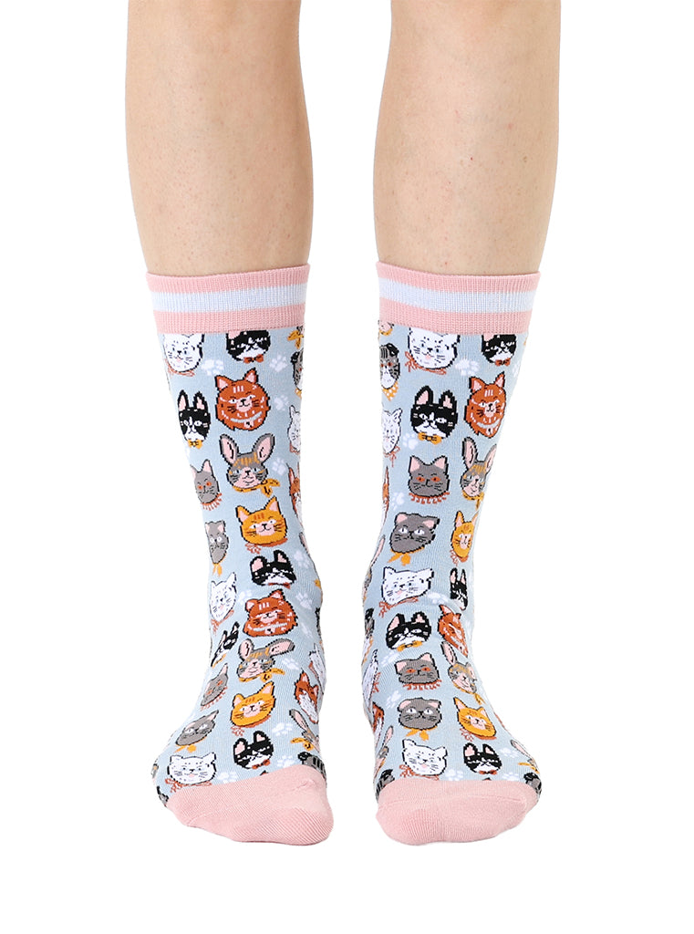 Women’s bamboo crew socks featuring a variety of cat face–themed patterns, shown worn on a person against a white background.