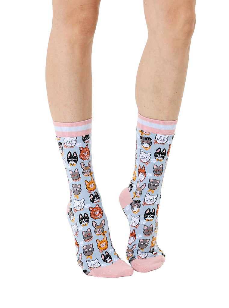 Women’s bamboo crew socks featuring a variety of cat face–themed patterns, shown worn on a person against a white background.