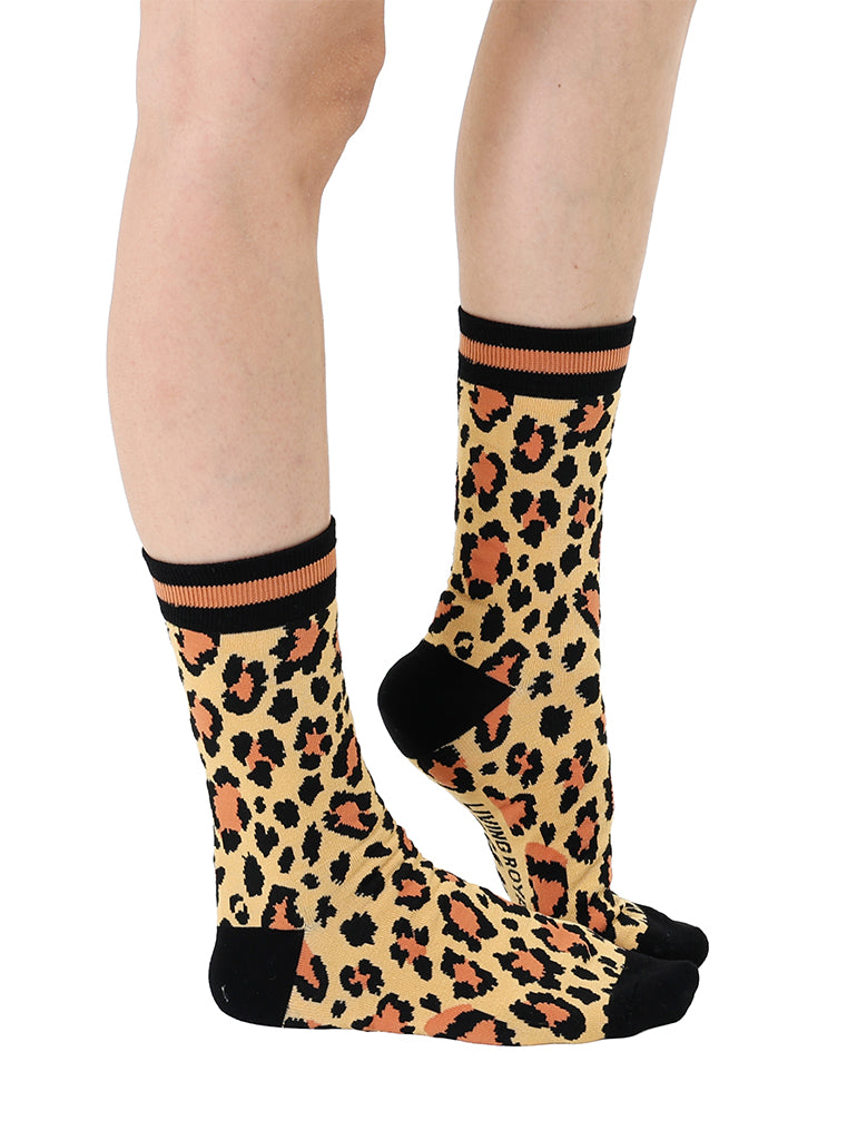 Women’s bamboo crew socks with a cheetah print pattern, shown worn on a person against a white background.