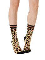 Women’s bamboo crew socks with a cheetah print pattern, shown worn on a person against a white background.