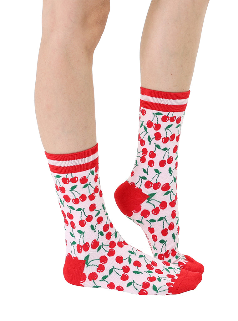 Red and light pink women’s bamboo crew socks featuring a cherry-themed pattern, shown worn on a person against a white background.