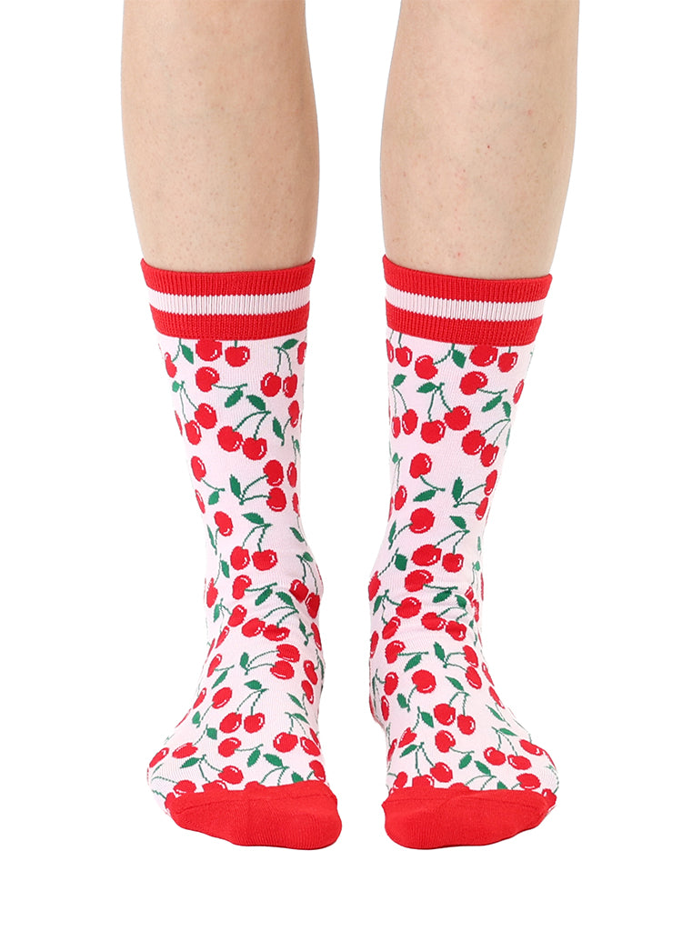 Red and light pink women’s bamboo crew socks featuring a cherry-themed pattern, shown worn on a person against a white background.
