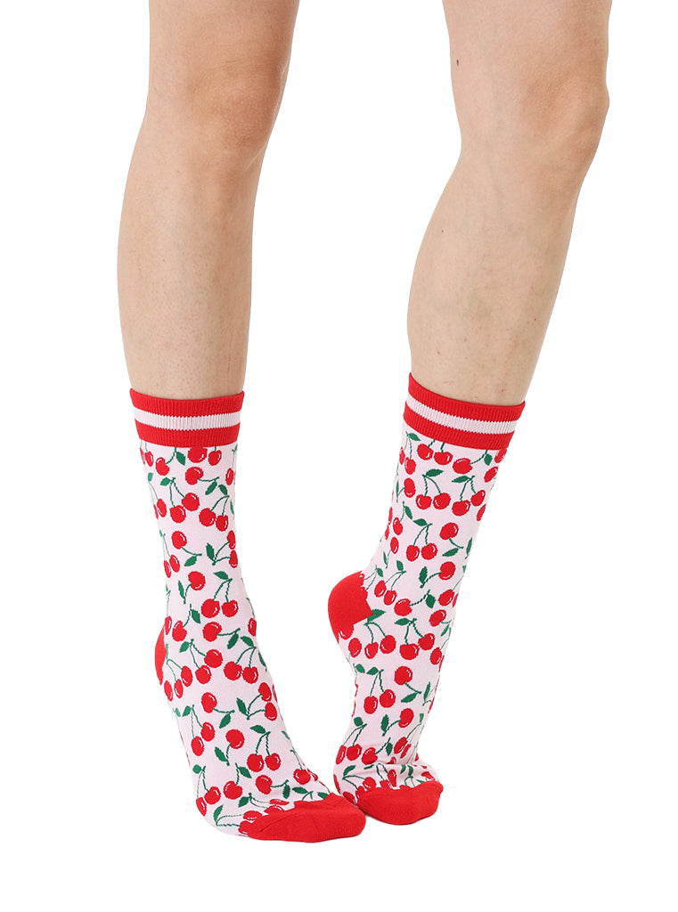 Red and light pink women’s bamboo crew socks featuring a cherry-themed pattern, shown worn on a person against a white background.