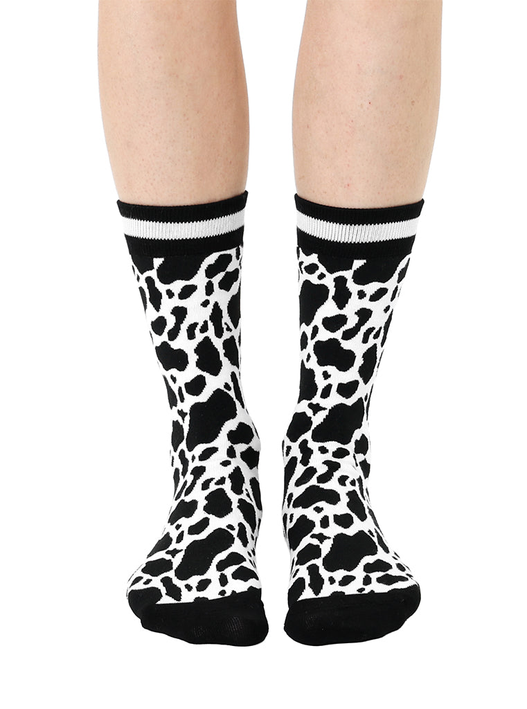 Women’s bamboo crew socks with a cow print pattern, shown worn on a person against a white background.