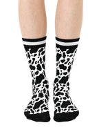 Women’s bamboo crew socks with a cow print pattern, shown worn on a person against a white background.