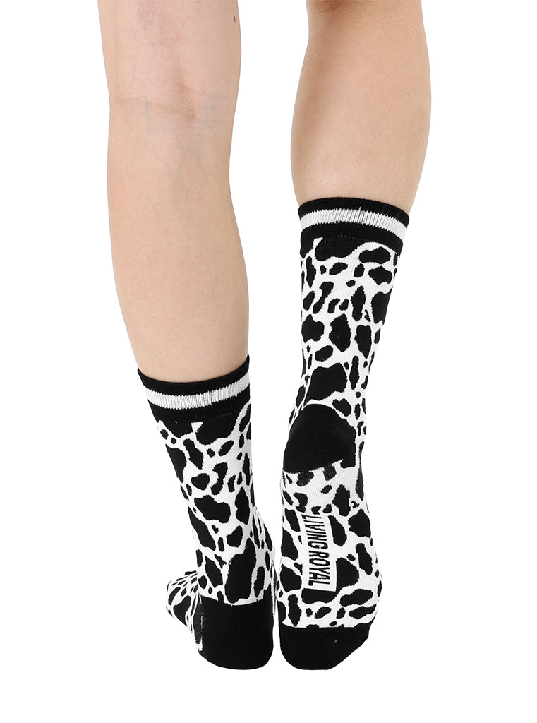 Women’s bamboo crew socks with a cow print pattern, shown worn on a person against a white background.