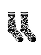 Women’s bamboo crew socks with a cow print pattern, shown on a white background.