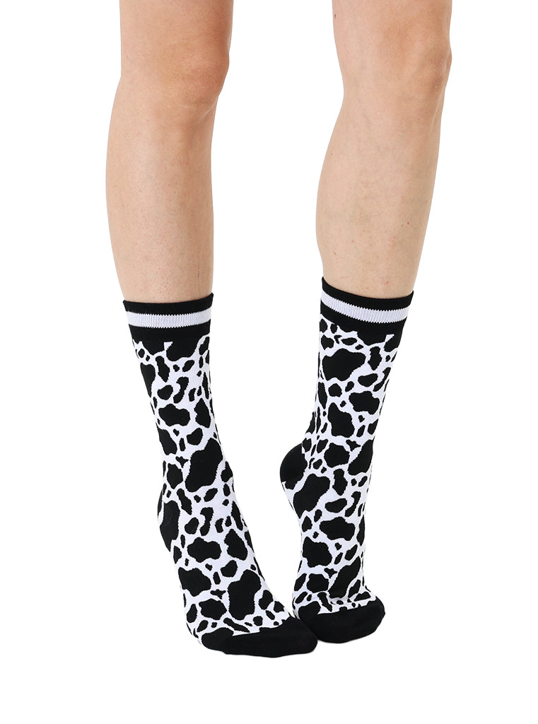 Women’s bamboo crew socks with a cow print pattern, shown worn on a person against a white background.