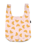 A shopper's bag with a croissant print, displayed on a white background.