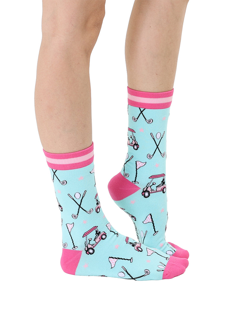 Light blue women’s bamboo crew socks with pink-striped cuffs, featuring a playful golf-themed print, shown worn on a person on a white background.