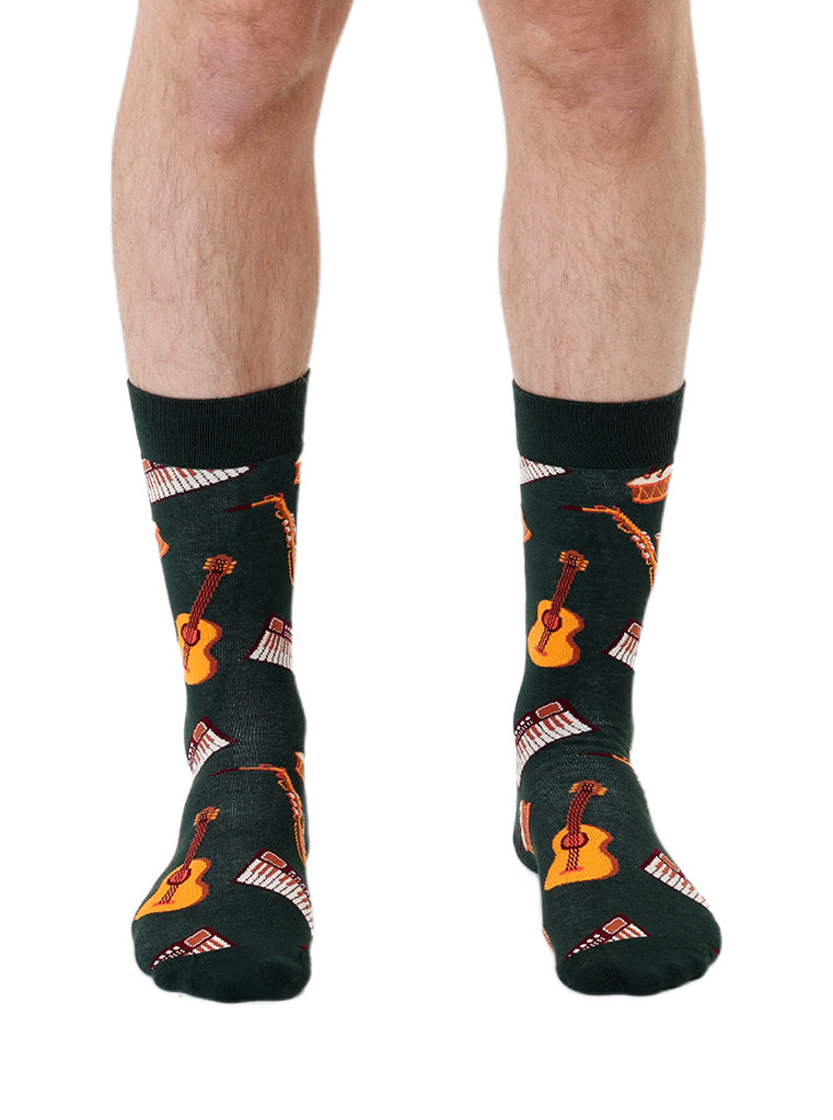 Dark green men’s bamboo crew socks featuring a musical instruments pattern, shown worn on a white background.