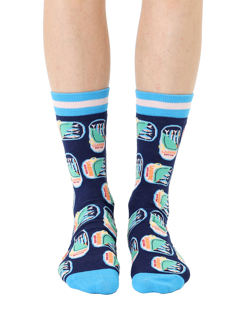 Blue women’s bamboo crew socks featuring a sardines can print, worn by a person on a white background