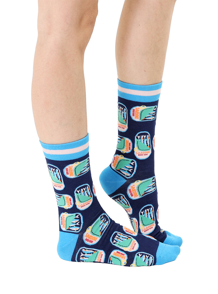 Blue women’s bamboo crew socks featuring a sardines can print, worn by a person on a white background