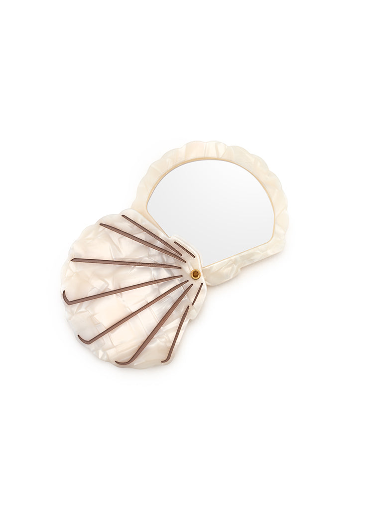 Compact mirror featuring a seashell design with a hinged mechanism, perfect for on-the-go use, displayed on a white background.