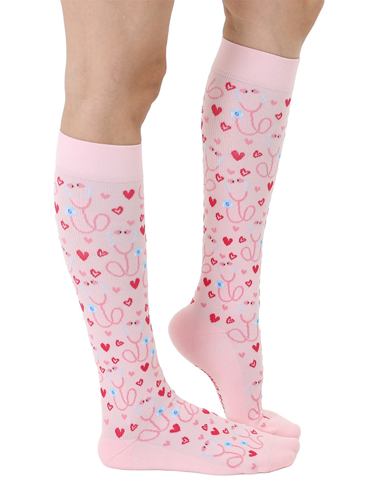 Pink padded compression socks featuring a stethoscope and hearts pattern, shown worn on a white background.