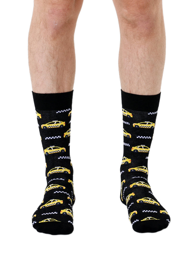 Black men’s bamboo crew socks with a yellow taxi print, worn on a white background.